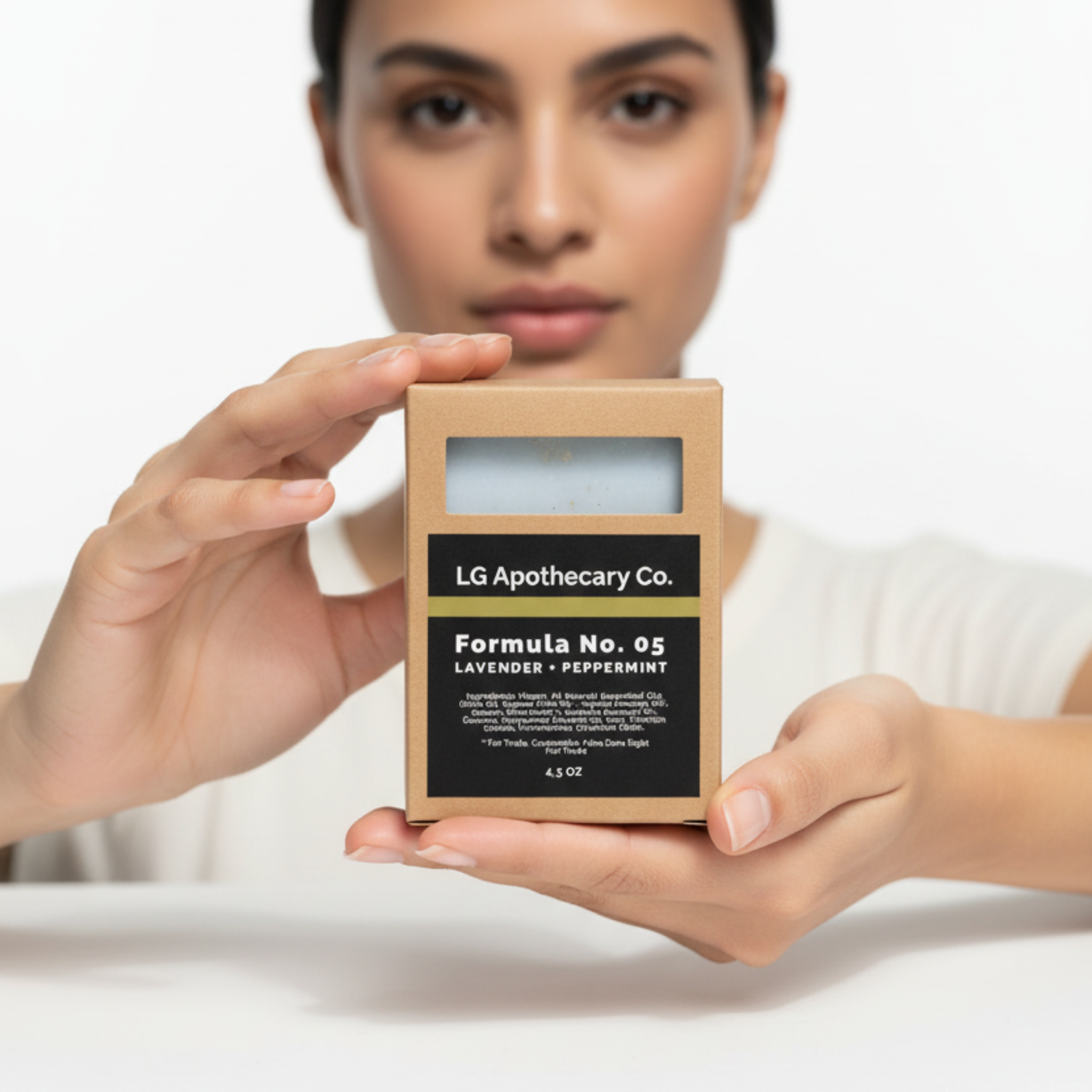 Woman holding a product packaging with 'LG Apothecary Co.' branding on a white background