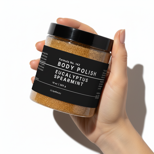 Hand holding a jar of body polish labeled 'Eucalyptus Spearmint' on a white background