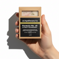 Hand holding a soap bar in a box with 'LG Apothecary Co.' branding on a white background