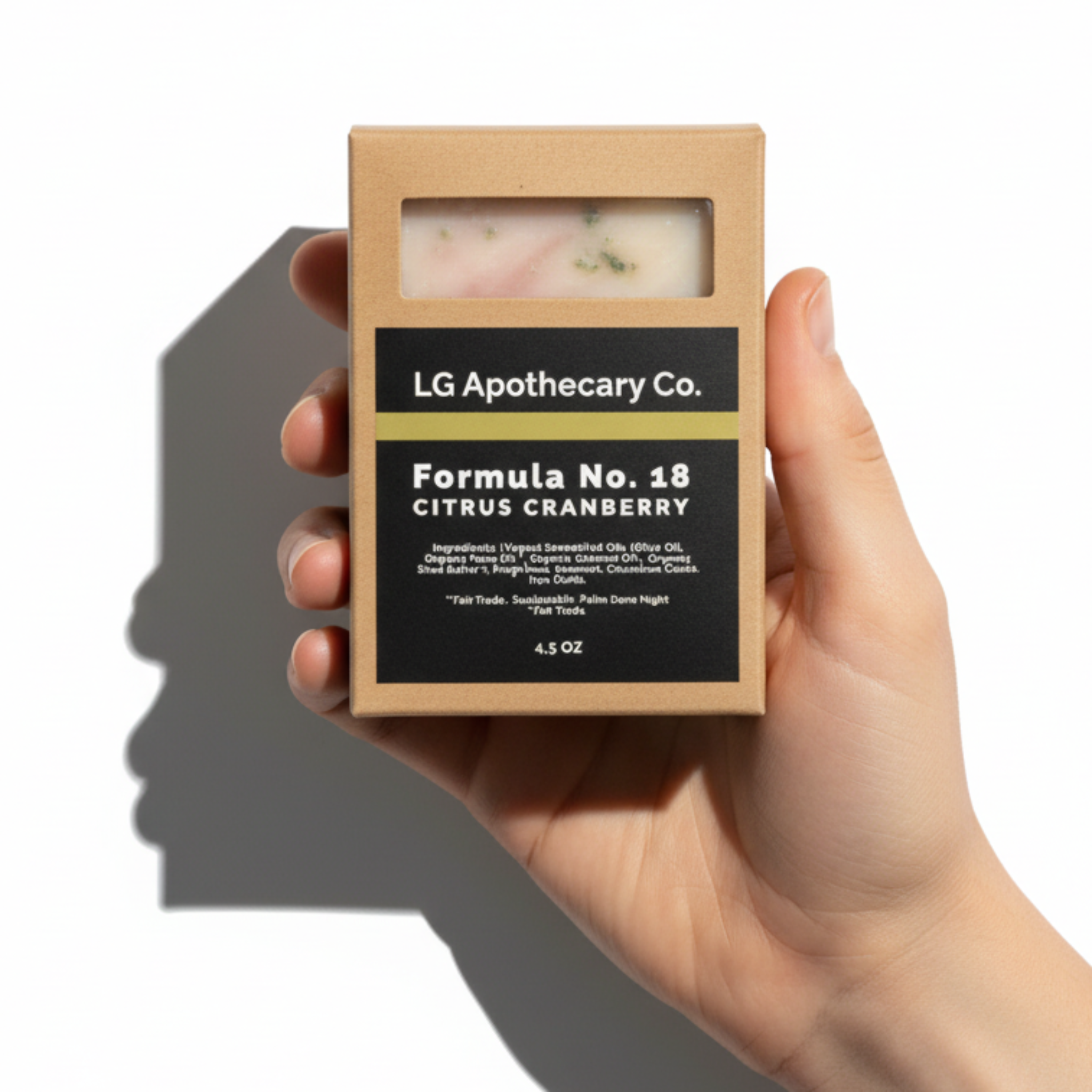 Hand holding a soap bar in a box with 'LG Apothecary Co.' branding on a white background
