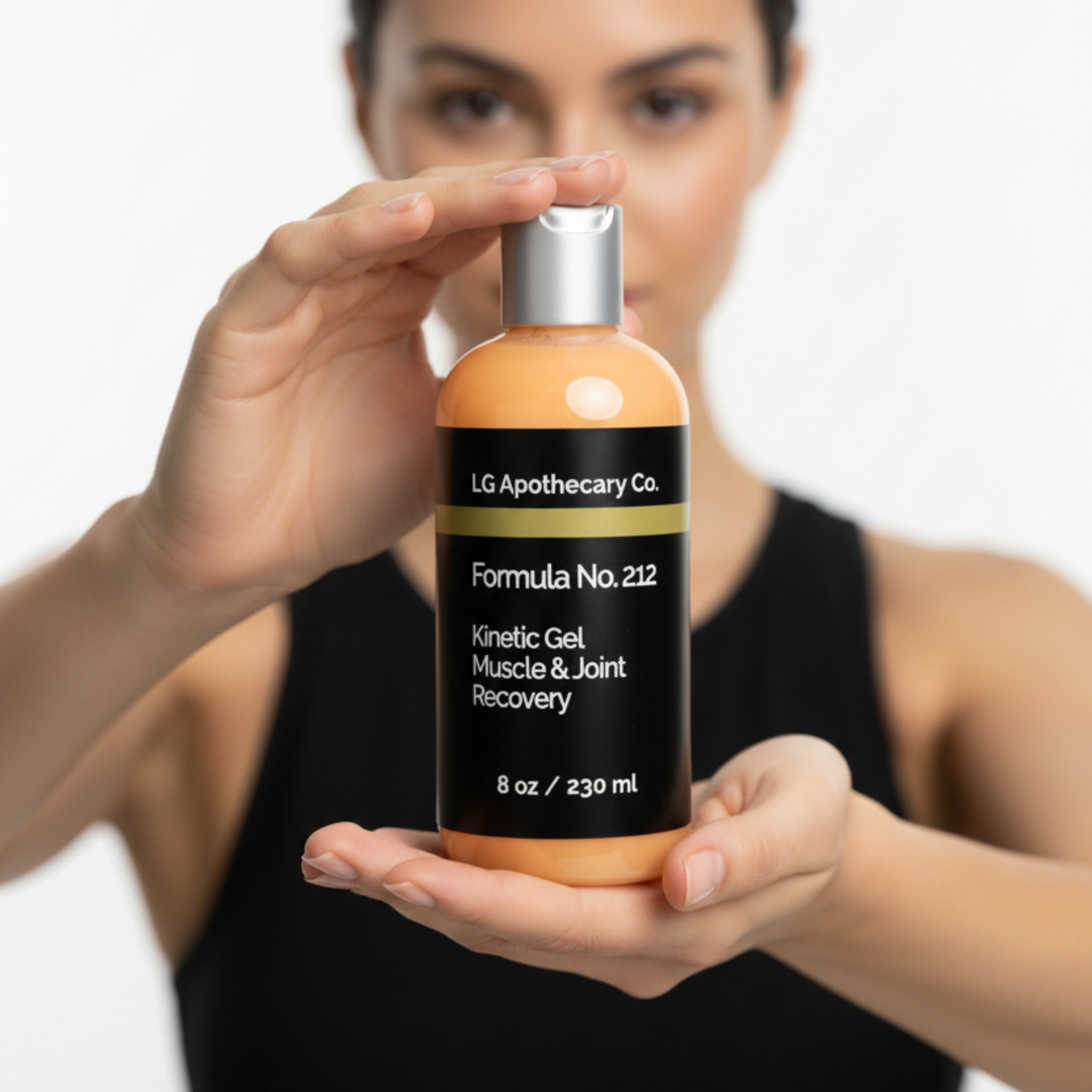 Woman holding a bottle of LG Apothecary Co. Kinetic Gel Muscle & Joint Recovery