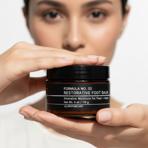 Person holding a jar of 'Formula No. 35 Restorative Foot Balm' against a white background