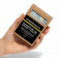 Hand holding a soap packaging box labeled 'LG Apothecary Co. Formula No. 53 Berries Vanilla' on a white background