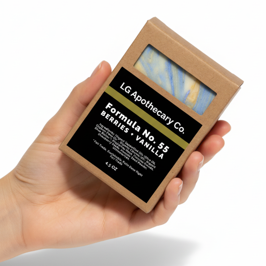 Hand holding a soap packaging box labeled 'LG Apothecary Co. Formula No. 53 Berries Vanilla' on a white background