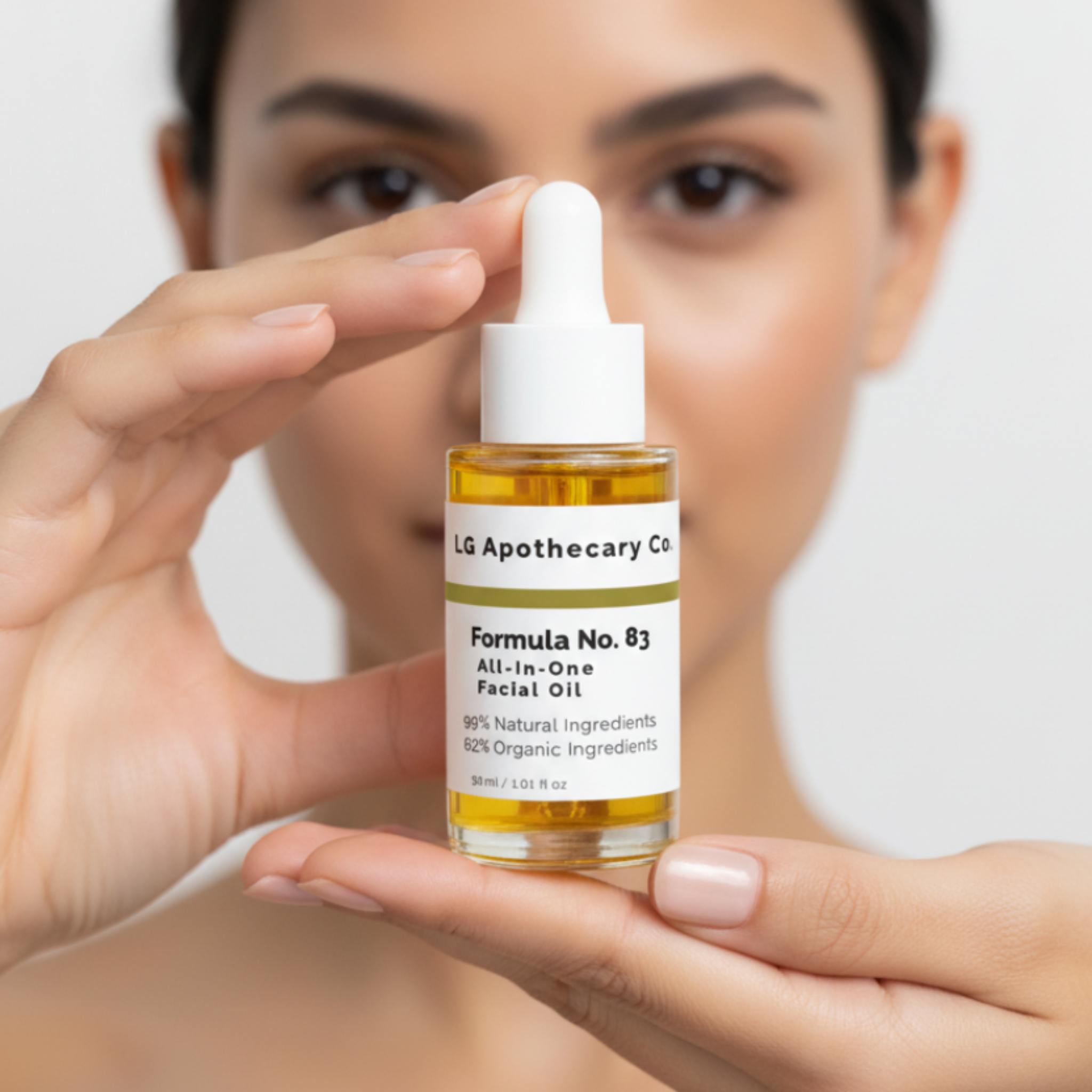 Person holding a bottle of LG Apothecary Co. facial oil against a neutral background