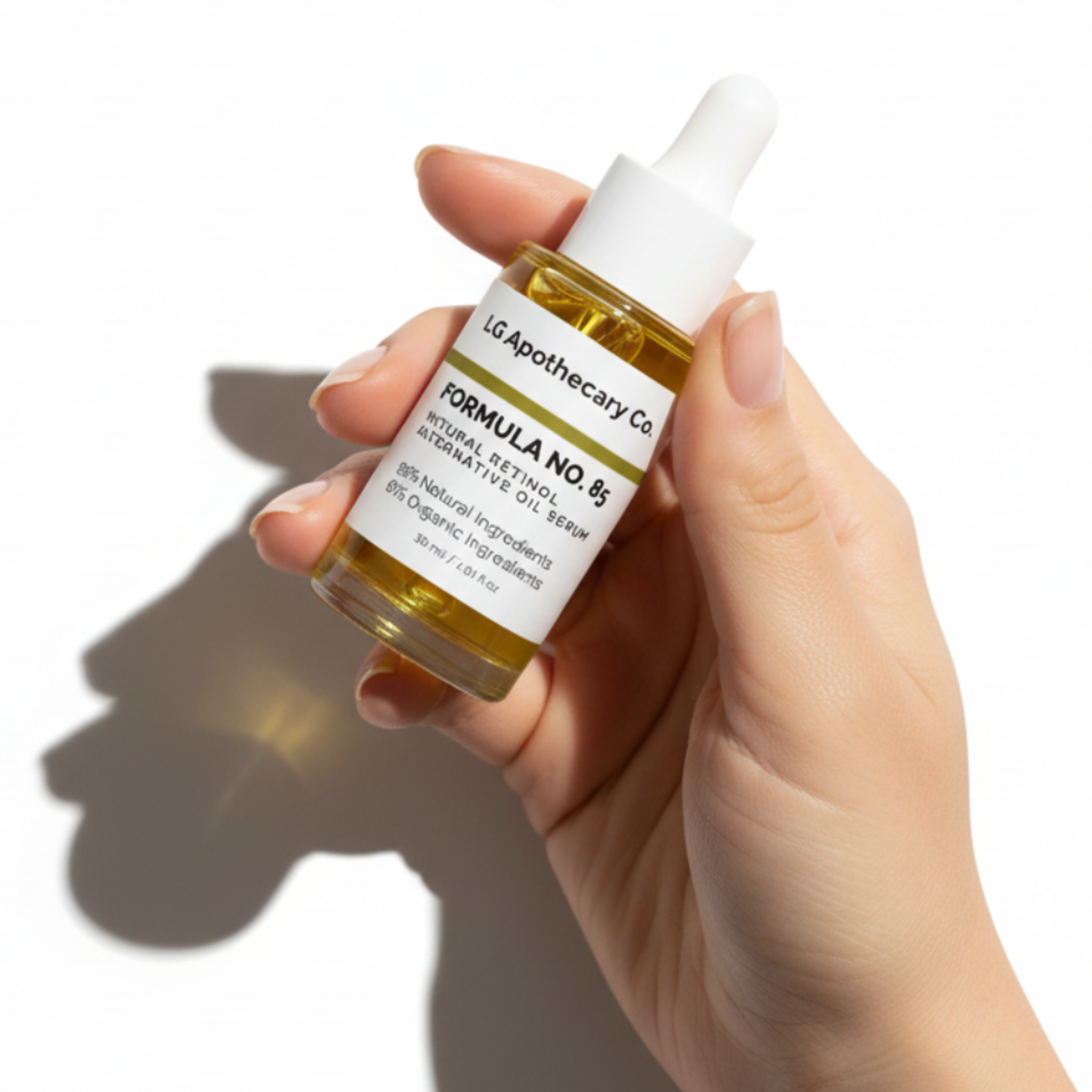 Hand holding a bottle of skincare serum with a white label on a white background