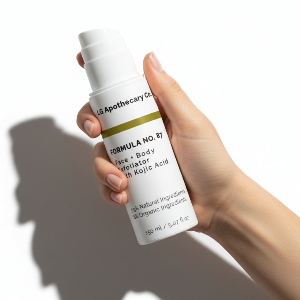 A hand holding a bottle of Formula No. 87 Face & Body Exfoliator with Kojic Acid against a white background with cinematic shadows.