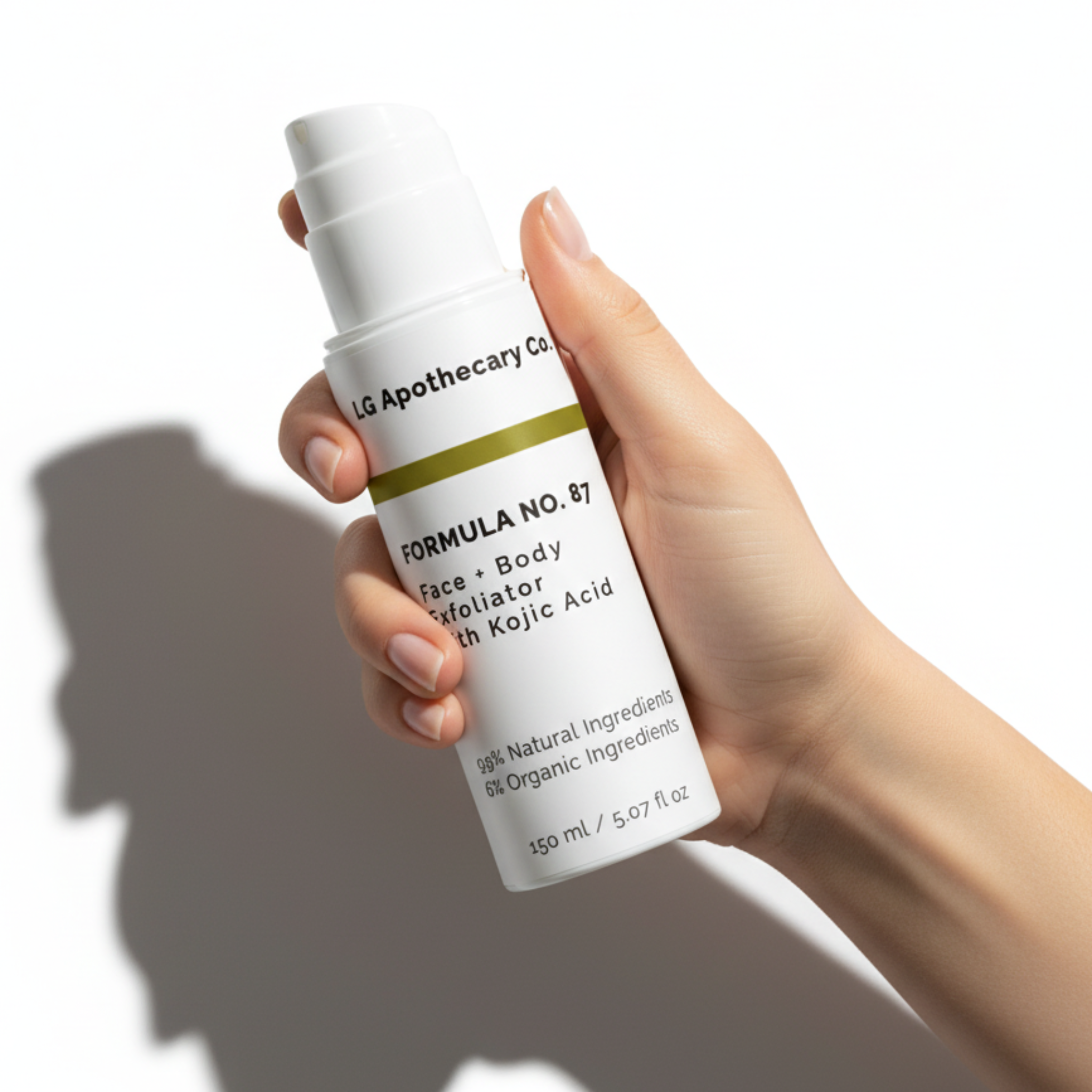 A hand holding a bottle of Formula No. 87 Face & Body Exfoliator with Kojic Acid against a white background with cinematic shadows.
