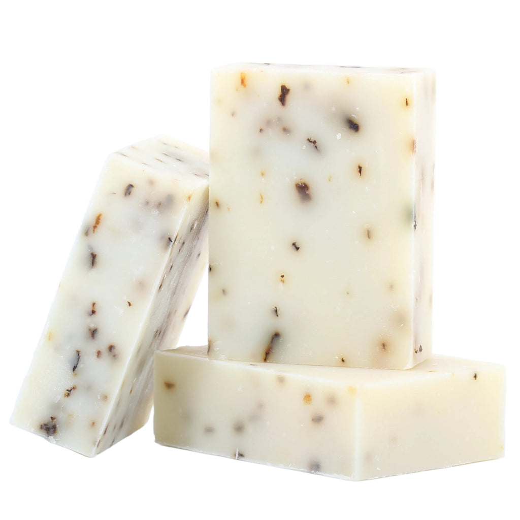 Three square-shaped soap bars with visible specks on a white background